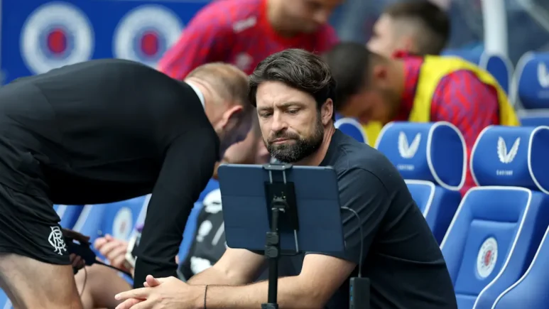 Russell Martin looks at a tablet in the Rangers dugout